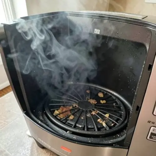 Por qué mi freidora de aire echa humo y cómo solucionarlo con grasa acumulada, cesta en uso y humo ligero en una cocina doméstica