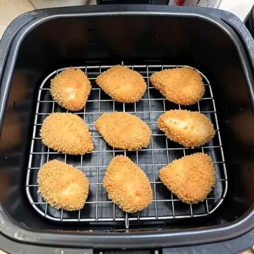 Cómo evitar que el rebozado se desprenda en la freidora de aire con piezas empanadas bien fijadas y espacio suficiente en la cesta