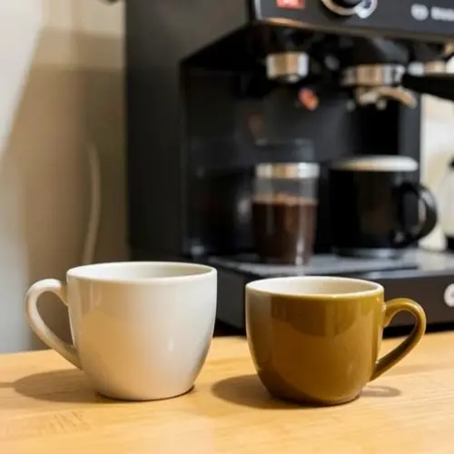 Café ya corregido con mejor color, crema más estable y dos tazas de distinto volumen para comparar la extracción
