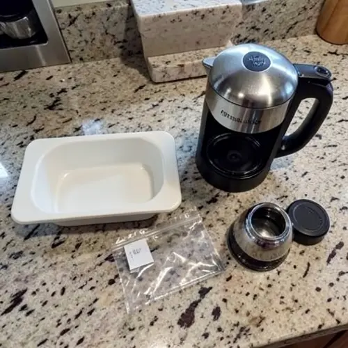 Cafetera revisada con bandeja de goteo limpia, junta en buen estado y accesorios secos antes de volver a montarlos